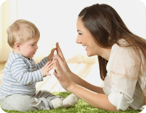 A Seattle Washington nanny playing patty cake with a small child who is having a great time under her care.