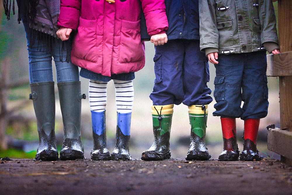 a group of children holding hands outside.